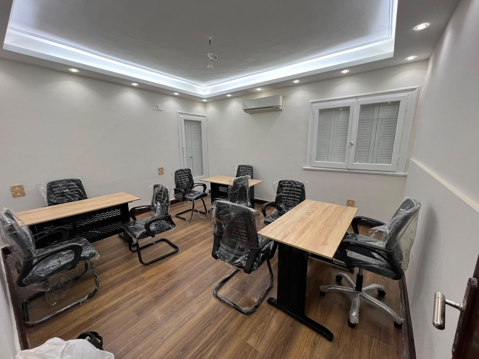 Private office at KAI with wooden desks and mesh chairs